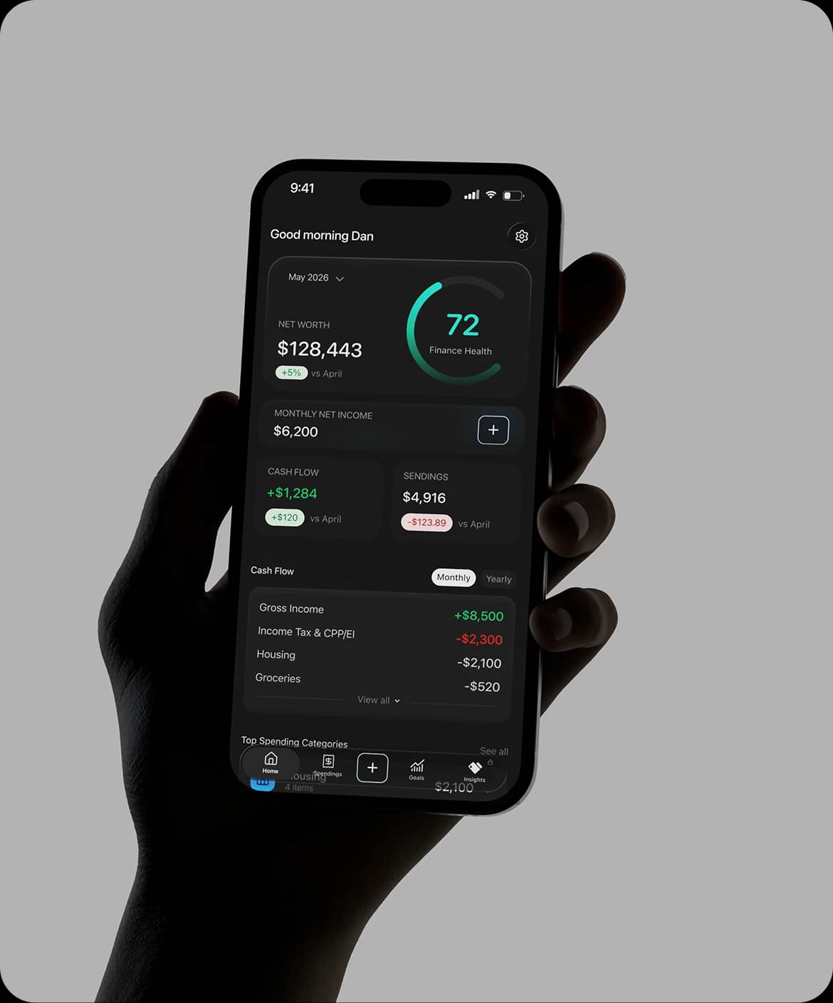 Hand holding a phone showing a finance dashboard with a 72 health score